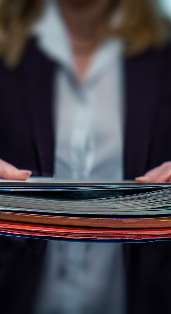 Personne tenant une pile de fichiers